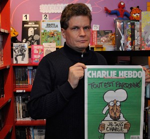 Petteri Oja med det senaste numret av Charlie Hebdo.
